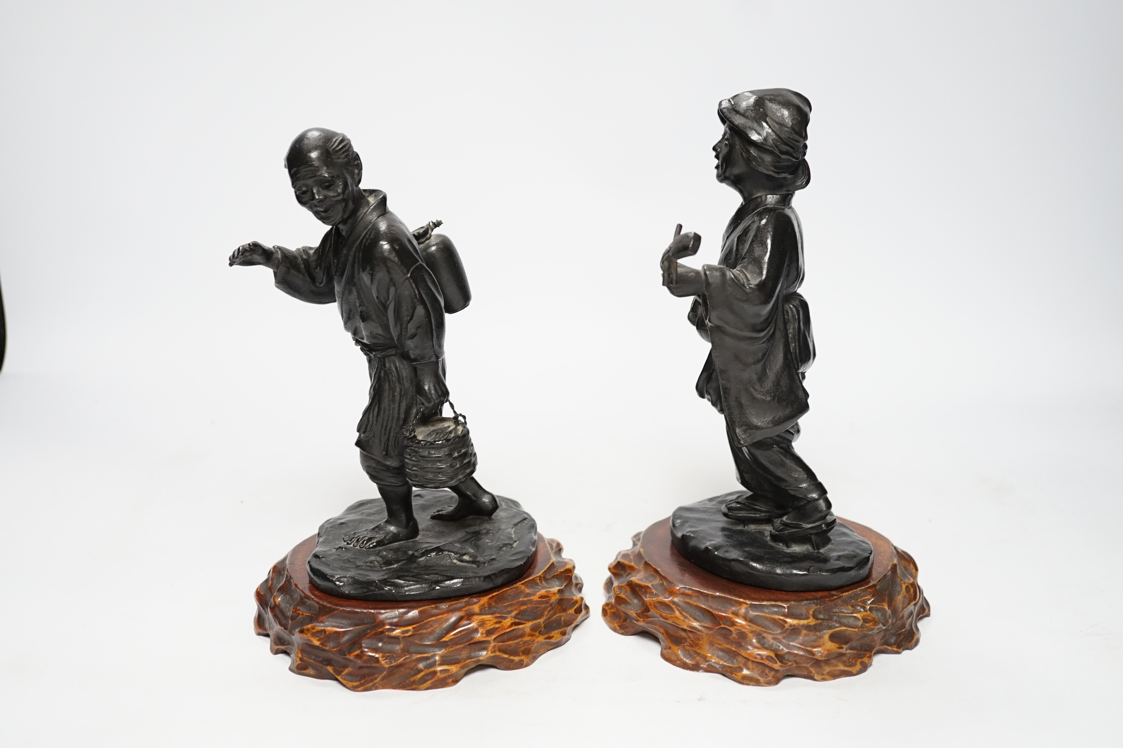 Two Japanese Meiji period bronzes, a water carrier and a woman playing a Shamisen, both signed, each with wooden plinths, largest 22cm high